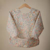 Picture of mushie Long Sleeve Baby Bib | Mess Free & Waterproof Fabric for Toddlers | Adjustable Fit for Ages 6-24 Months (Pastel Blooms)